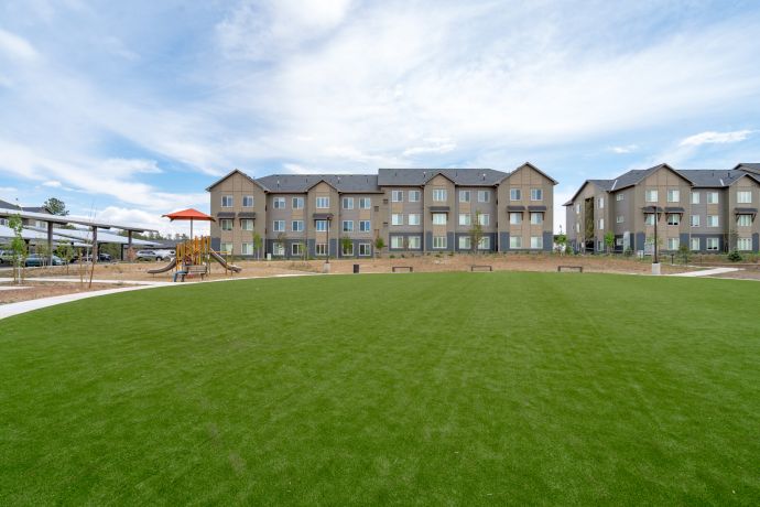 Sierra on 66 A vast courtyard and game lawn with a playground and benches with the Sierra on 66 apartments.